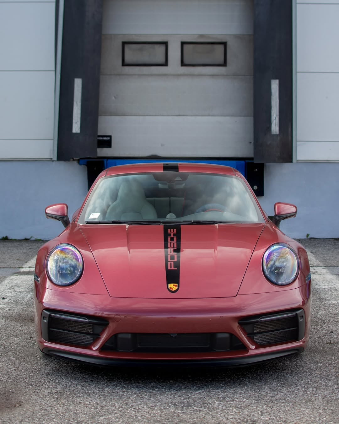 Oracal Gloss Red Brown Metallic installed on a Porsche car parked in front of a garage door