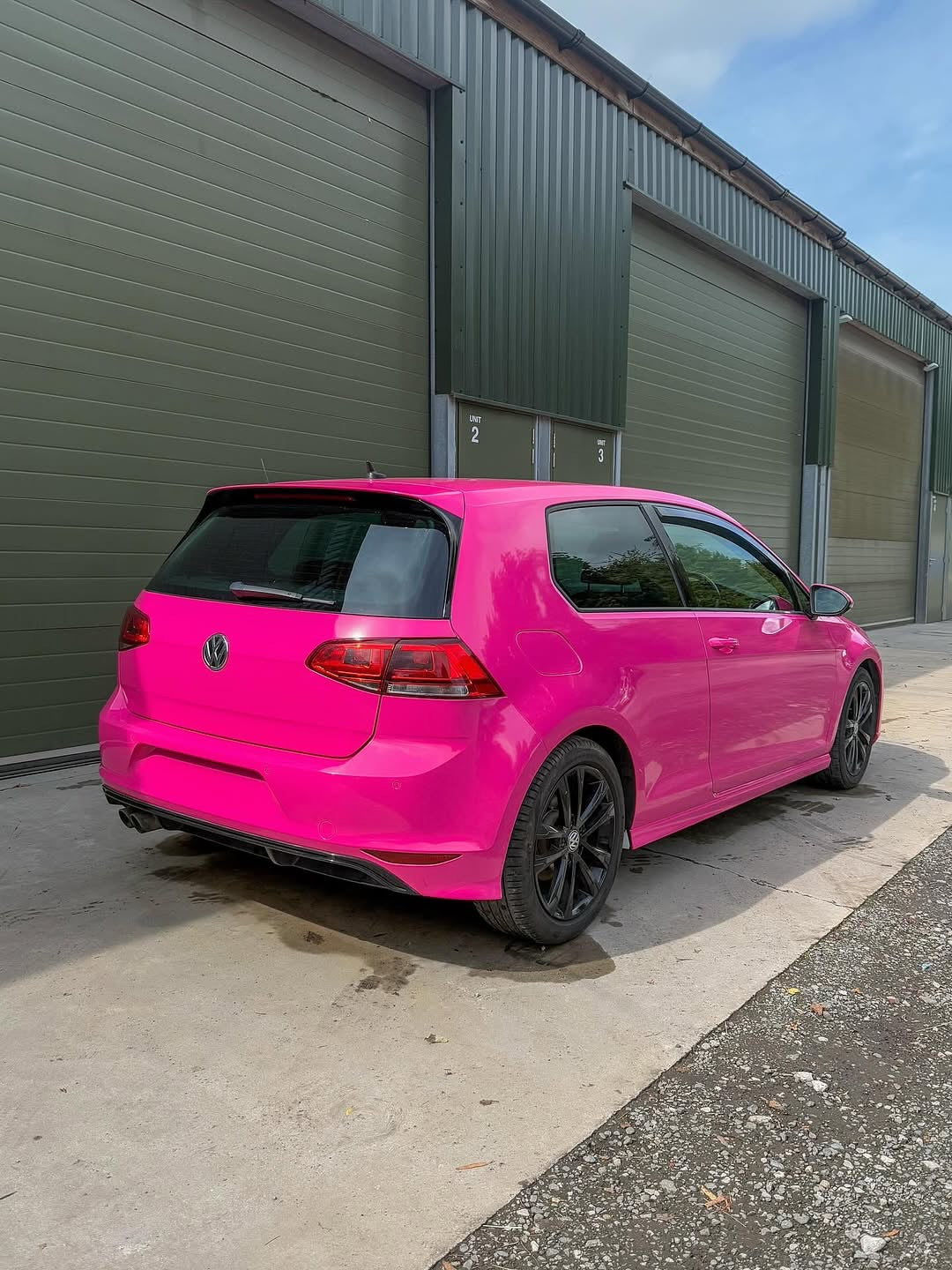Oracal Gloss Telemagenta installed on a Volkswagen, and parked in front of an industrial building