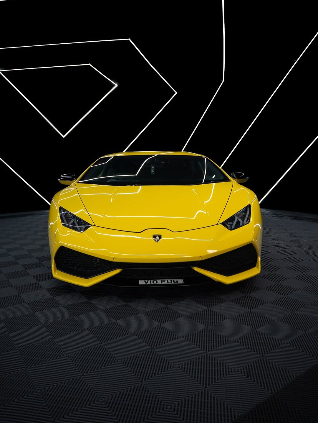 Oracal Gloss Traffic Yellow on Lamborghini with a black checkered floor and geometric white lines 