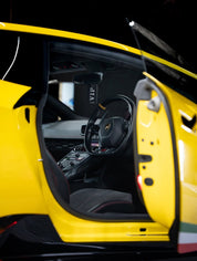 Lamborghini interior with open door, showing steering wheel and dashboard