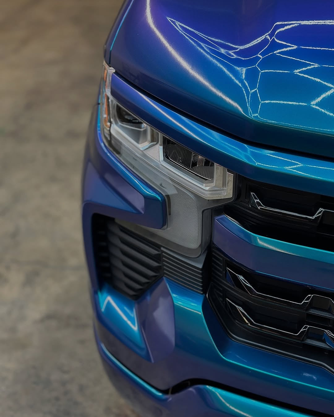 Close-up of an Oracal Gloss Ultramarine Violet installed on a truck's front grille and headlight