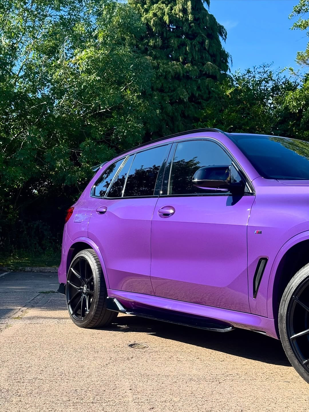 SUV with Oracal Gloss Violet Metallic installed wrap, parked on a road with trees