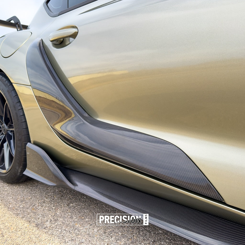 Close-up of a car's side panel with carbon fiber texture and Oracal Gloss Zinc Metallic installed