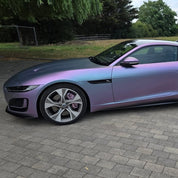 Luxury car with Oracal Matte Amethyst wrap on a paved surface with greenery