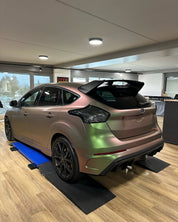 Oracal Matte Avocado car on a lift in a showroom