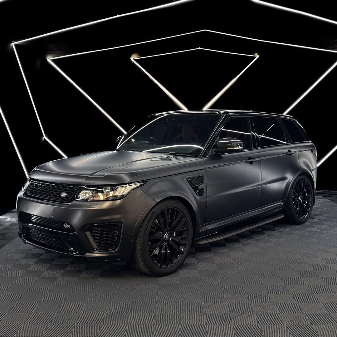 Oracal Matte Black installed on an SUV on a dark checkered floor with geometric light design