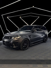 Oracal Matte Black installed on an SUV on a dark checkered floor with geometric light design