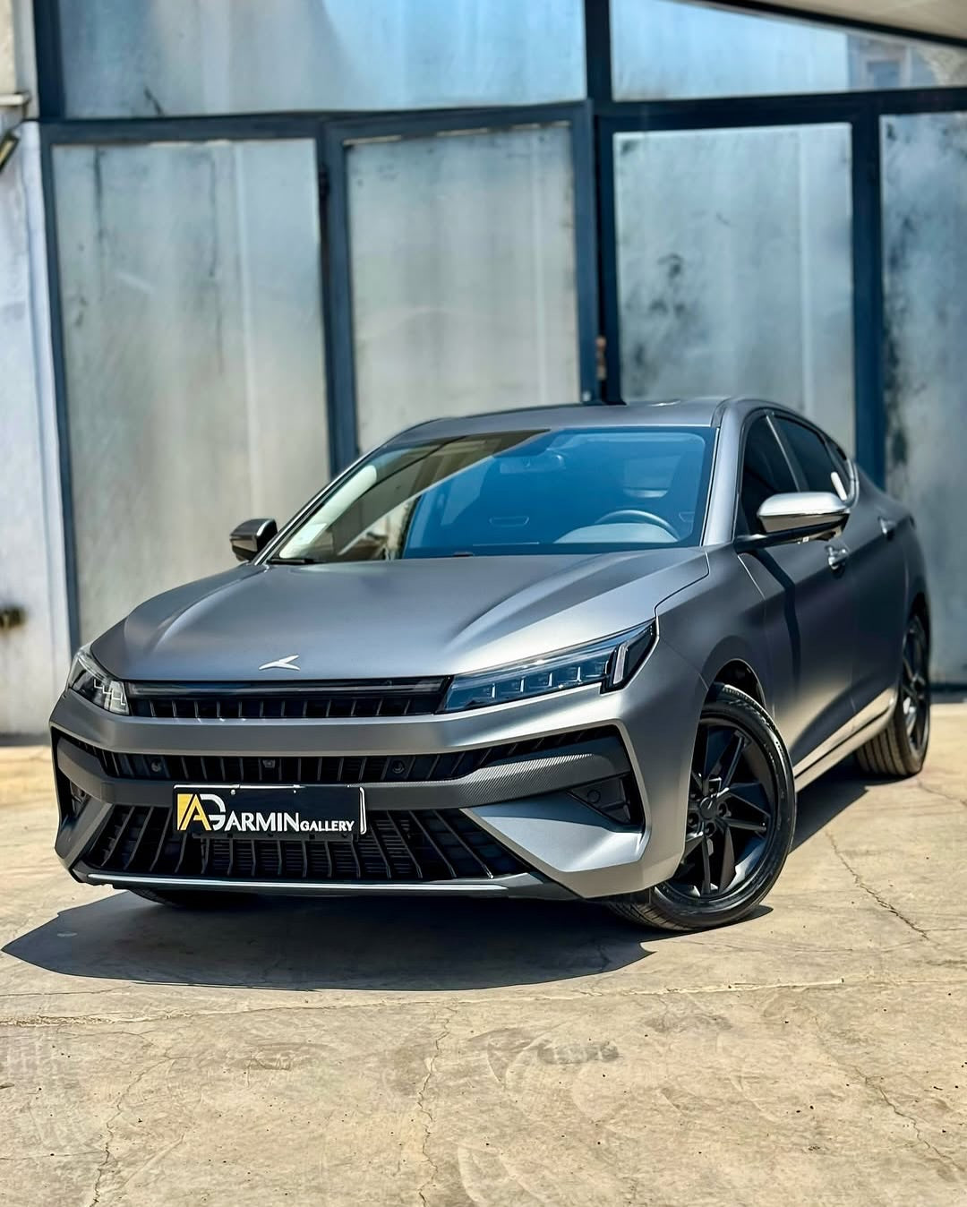 Oracal Matte Charcoal Metallic wrap installed on an SUV, which is parked in front of a glass building