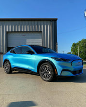 Oracal Matte Green Blue installed on a Ford Mustang parked in front of a building with a clear blue sky