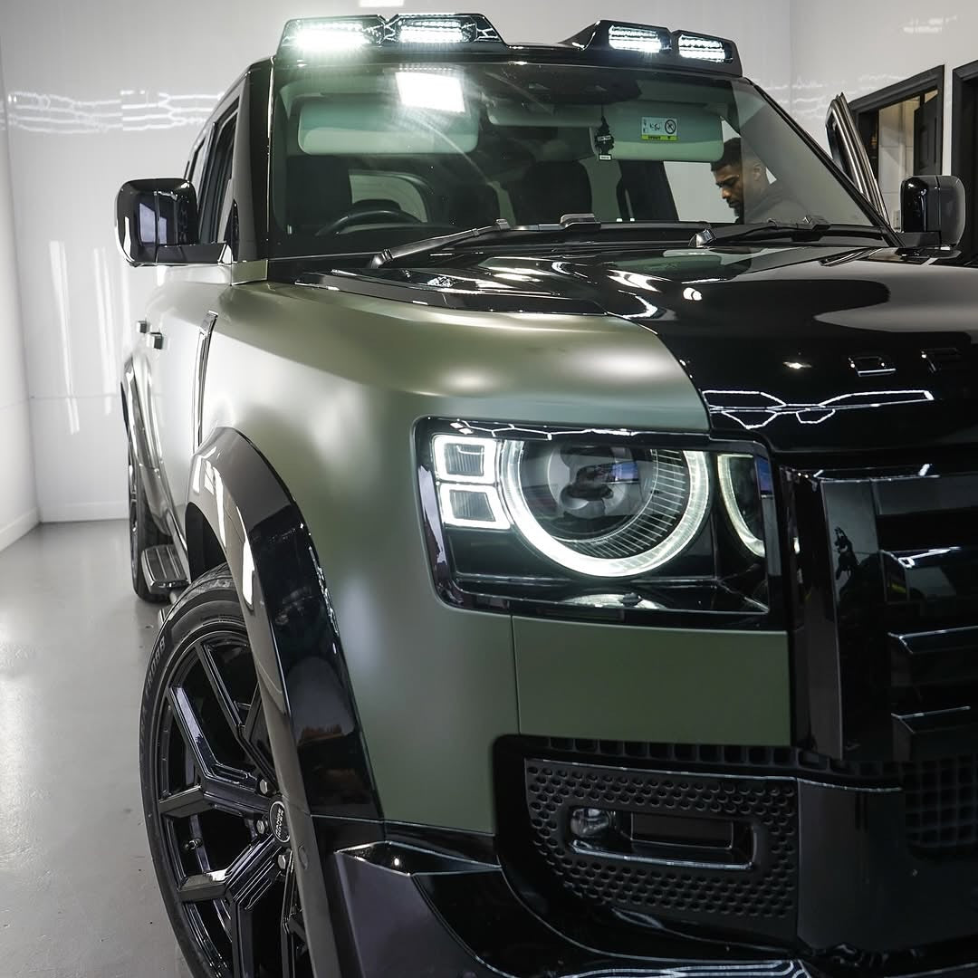 Oracal Matte Nato Olive installed on an SUV with distinctive headlights in a showroom