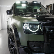 Oracal Matte Nato Olive installed on an SUV with distinctive headlights in a showroom