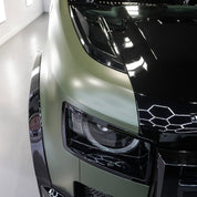 Close-up of a car's front grille and headlight with Oracal Matte Nato Olive installed