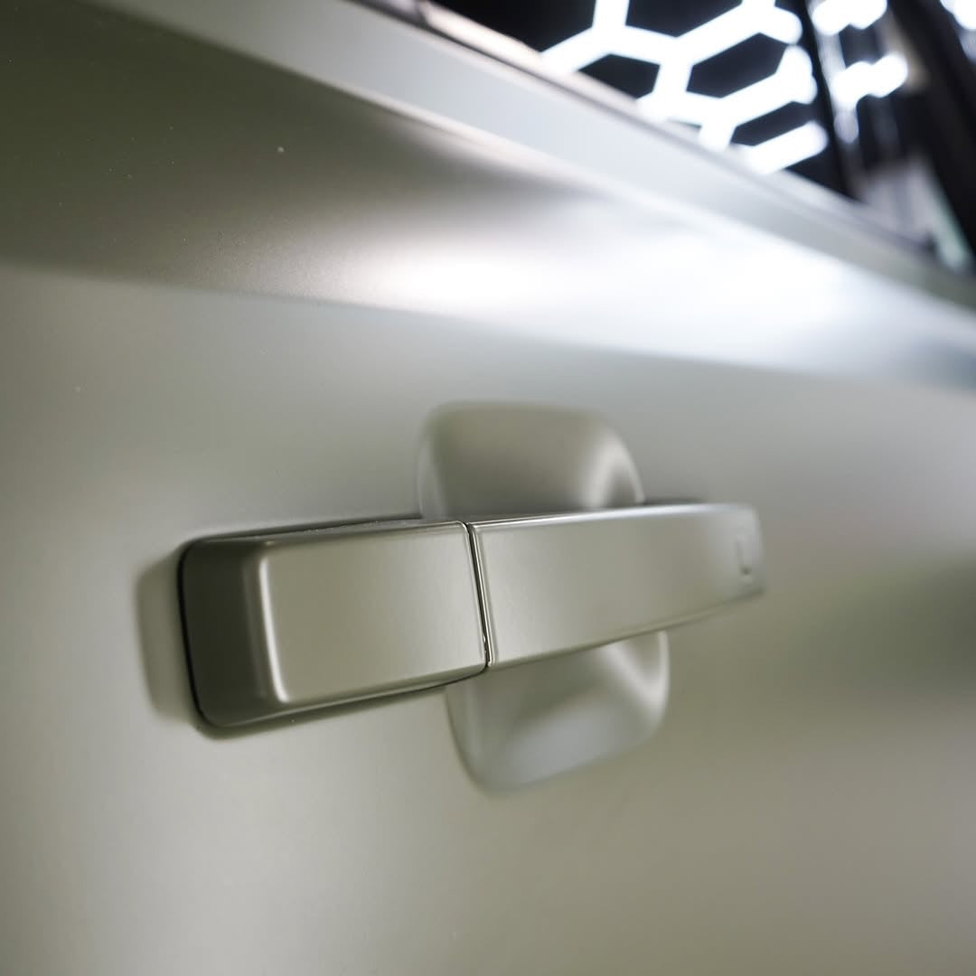 Close-up of a metallic door handle on a vehicle with Oracal Matte Nato Olive installed