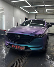 Oracal Matte Ultramarine Violet Mazda car in a garage with 'Raywan' branding on the license plate