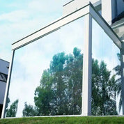 External view of large glass panelled building with silver reflective window film installed