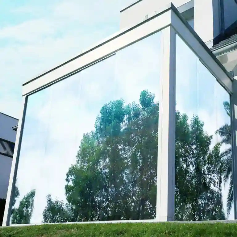 External view of large glass panelled building with silver reflective window film installed