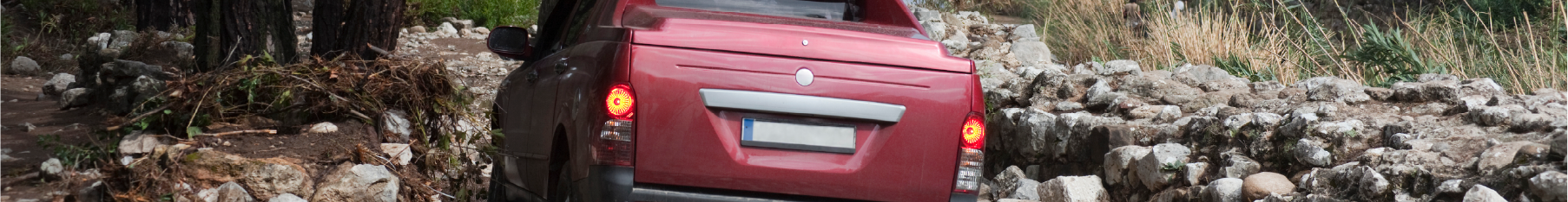 Professional Ssangyong window tint on a red truck on a rocky terrain