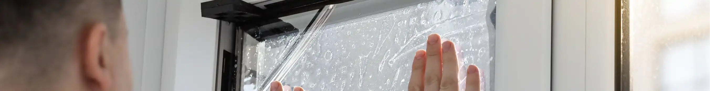 Person installing window film in High Wycombe to a house window