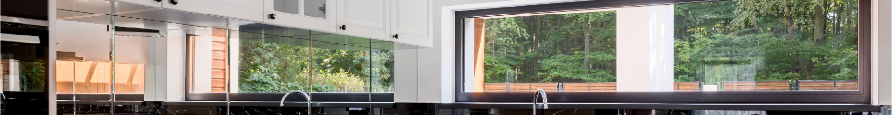 Residential window film on a modern kitchen's windows with trees in the abckground