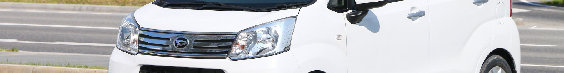 Cropped image of a white Daihatsu  on a road with Daihatsu window tints installed