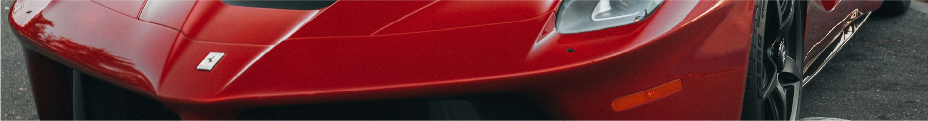 Close-up of a red Ferrari car on a road with Ferrari window tints installed