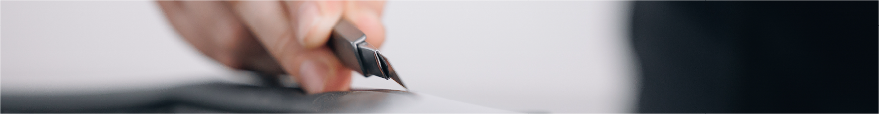 Close up of window tint cutting knife in use