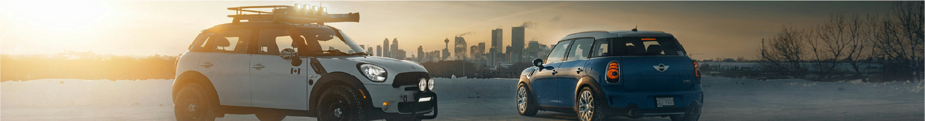 Two Minis with Mini window tints installed and a background of a city as the sun is setting