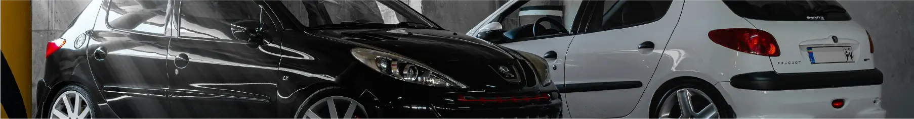 Two Peugeots parked in a garage with newly installed Peugeot window tints