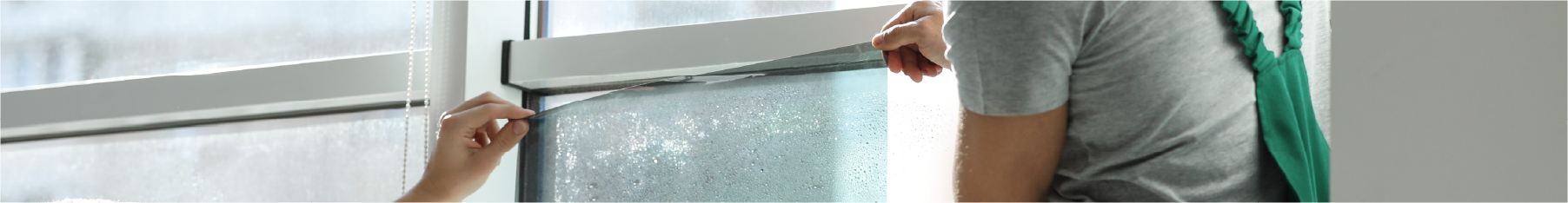 Two fitters installing window film using a window film installation kit