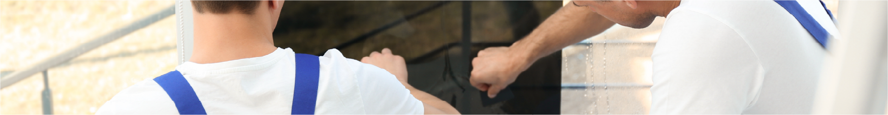 Two fitters installing tint using window film tools